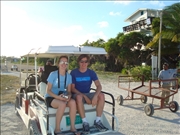 Katarena & Enrique on the back of a golf cart taxi at the Caye Caulker airstrip